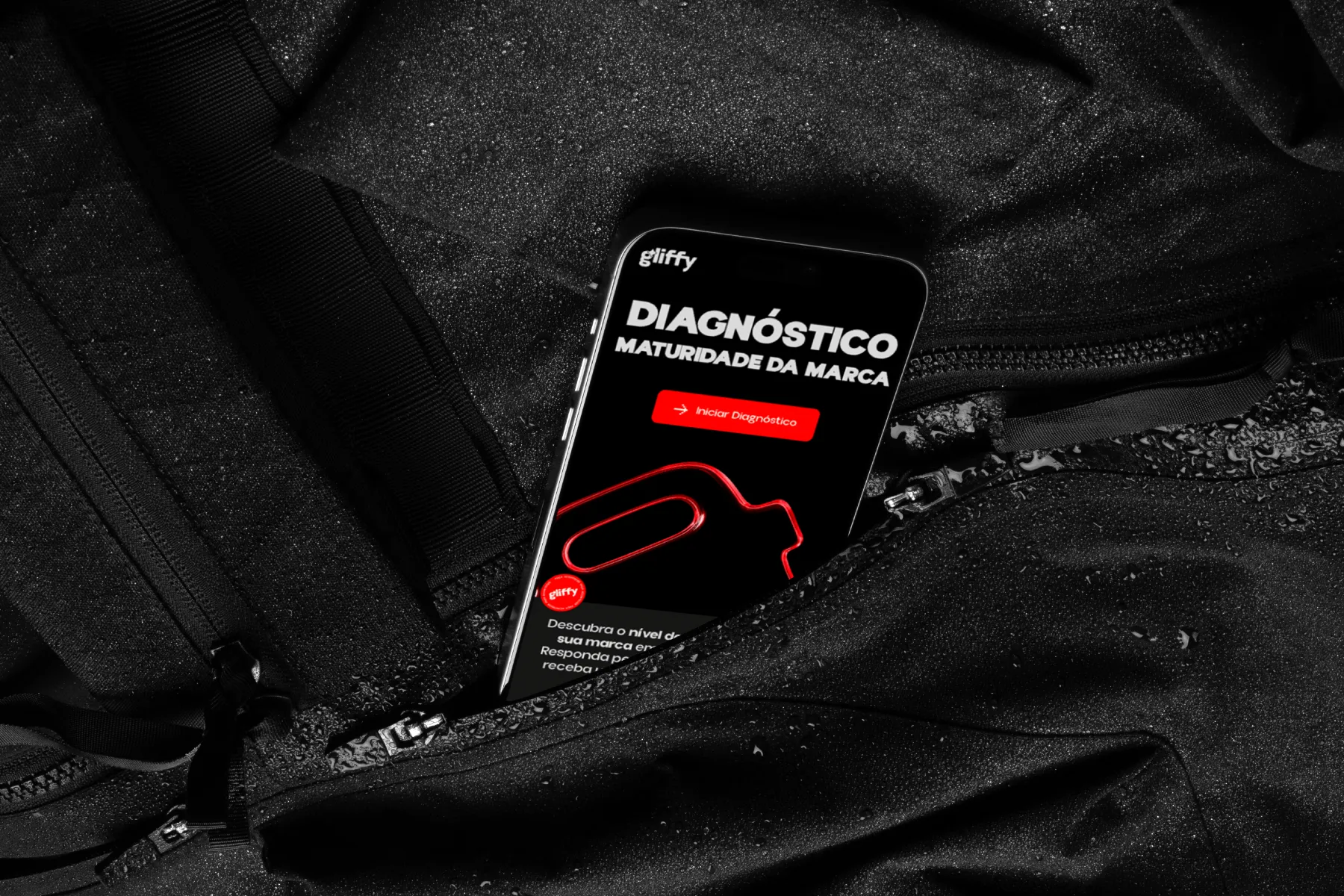 Celular exibindo o Diagnóstico de maturidade da marca da Gliffy, sobre tecido preto com gotas de água